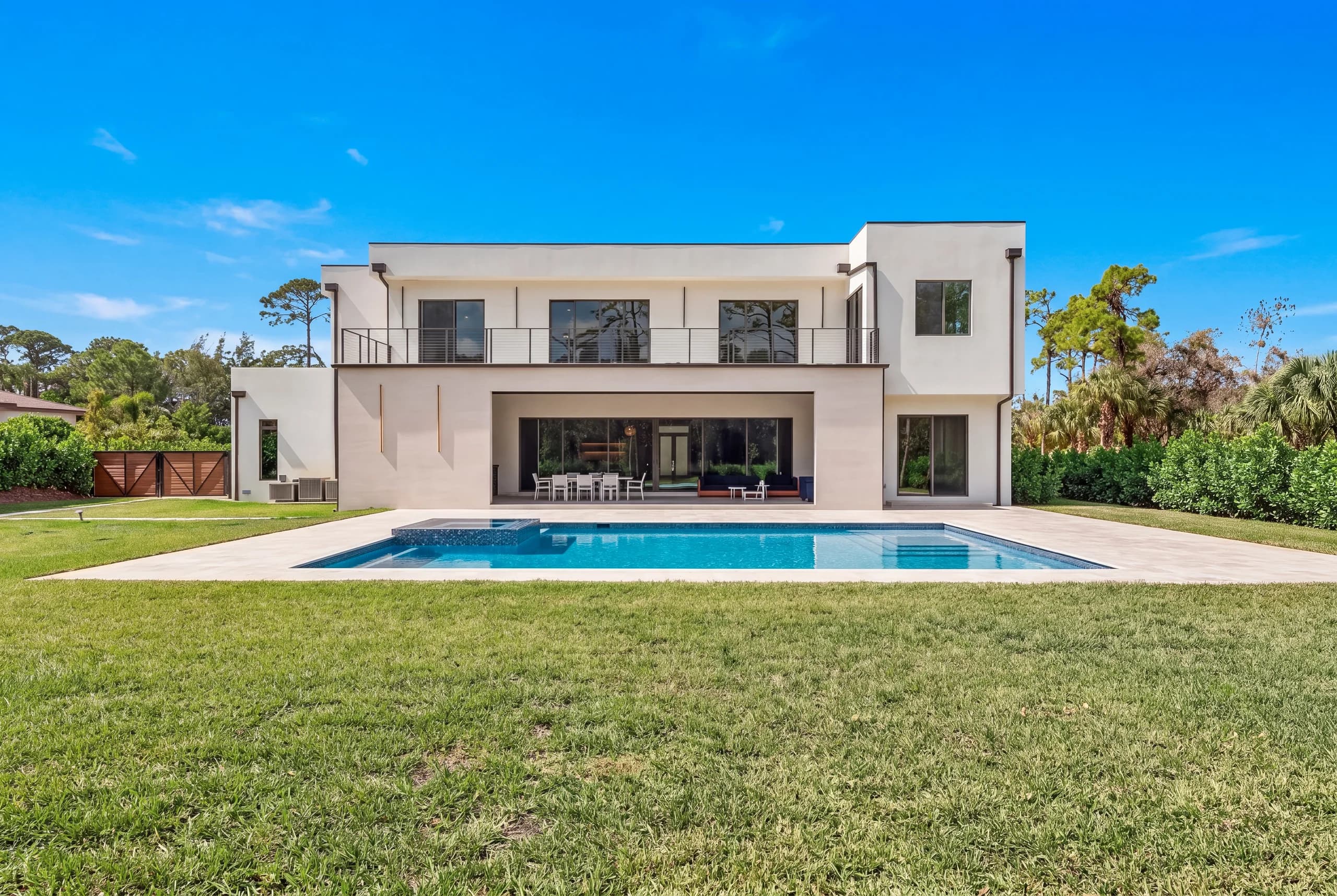 Symmetrical modern rear elevation and geometric pool in bright daylight