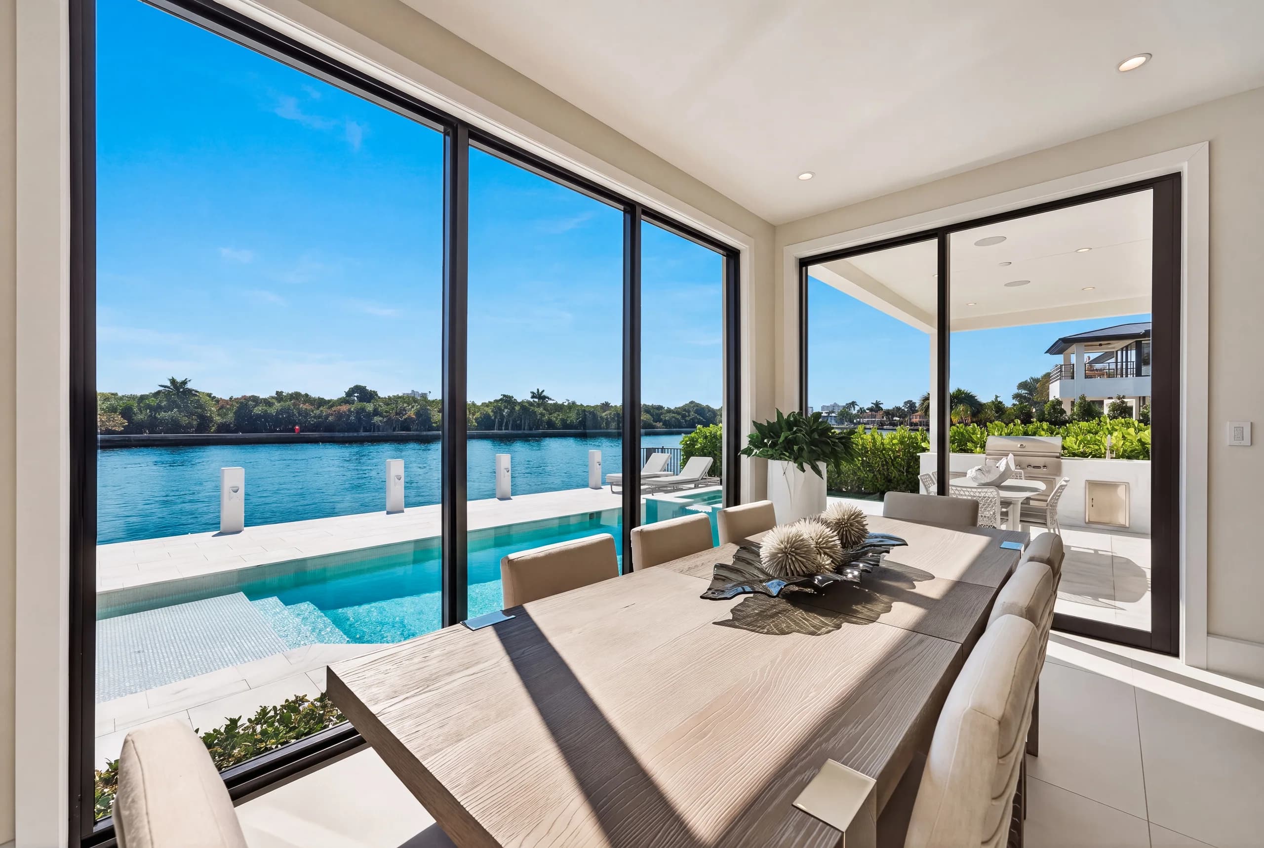 Waterfront dining room opening to a pool and Intracoastal view