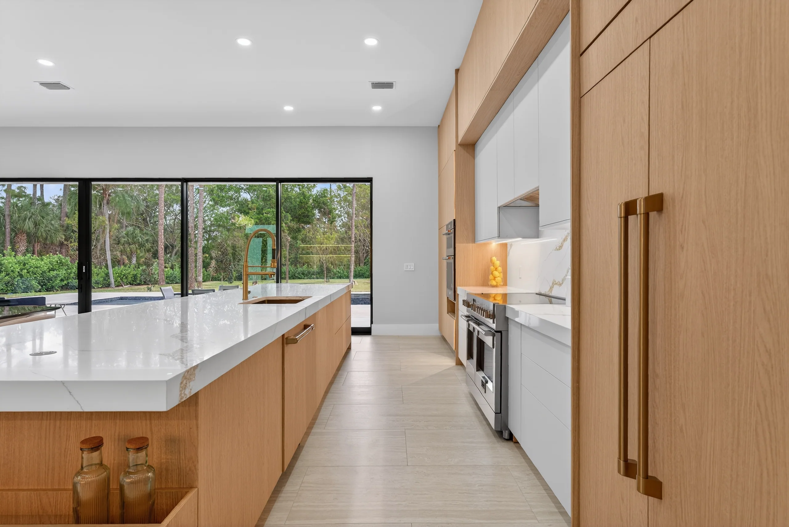 Oak cabinetry and pale stone island overlooking the garden