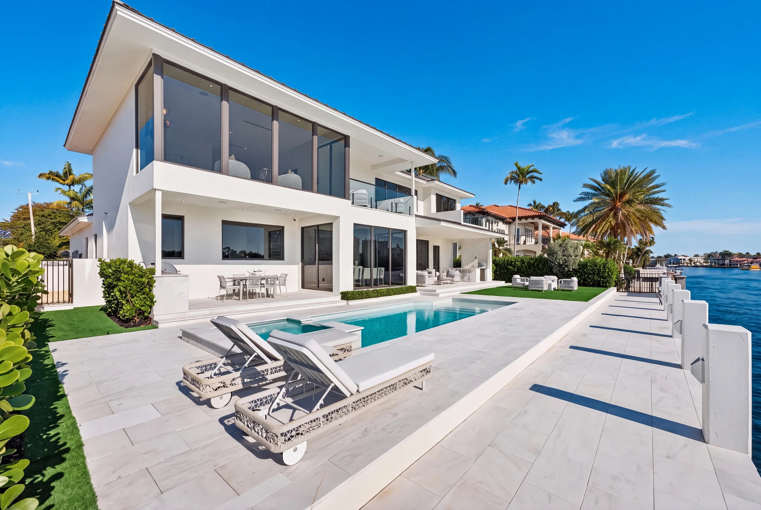 Angular waterfront residence beside a pool and pale stone terrace